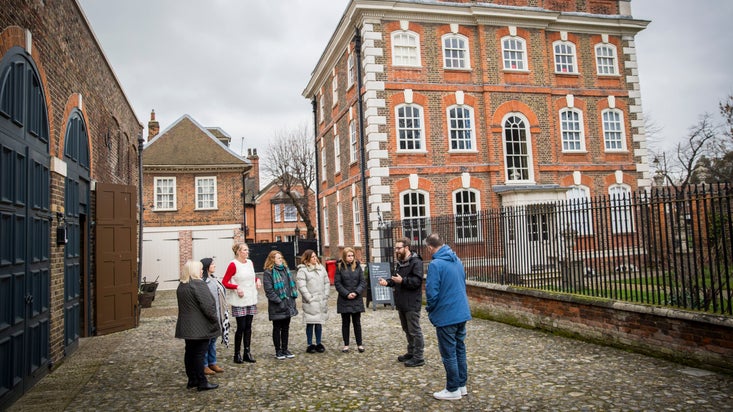 Visitors on a guided tour outside Rainham Hall, London